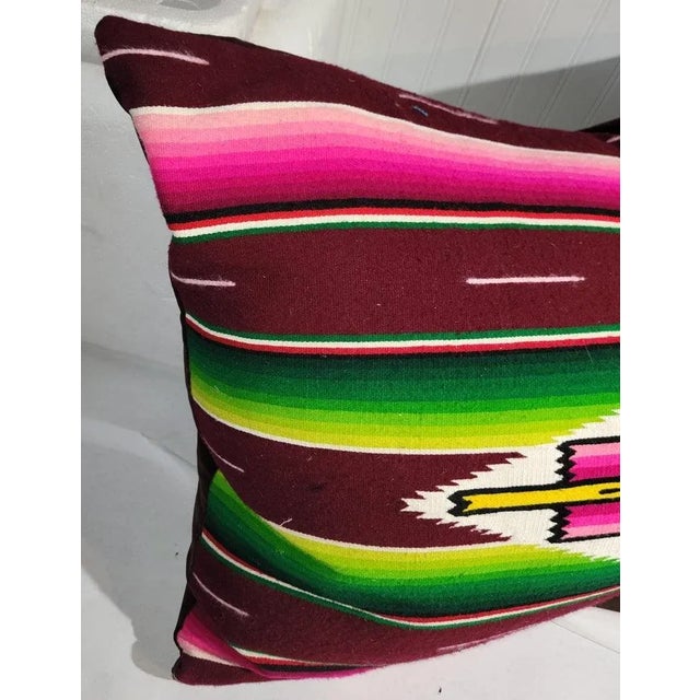 Mexican serape pillow with the center eye design.The backing is a deep maroon velvet and the in sert is down & feather fill.