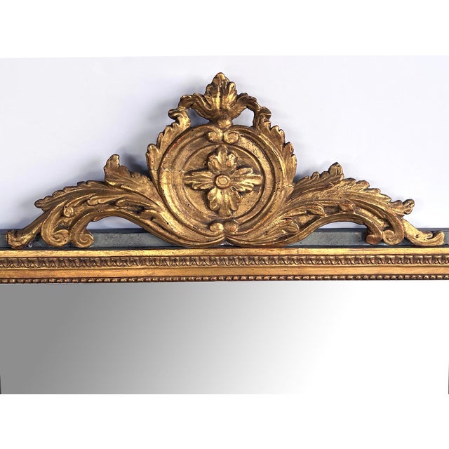 the rectangular mirror plate within a classically-inspired giltwood frame with beaded slip and leaf band outer edge all...