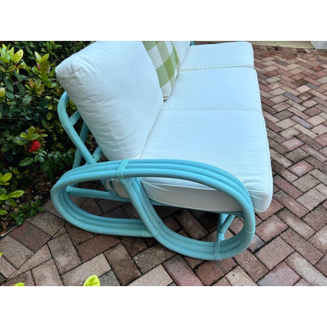 Pretzel rattan sofa refurbished in a modern twist with blue color and new white outdoor cushions. Mid century charm with...