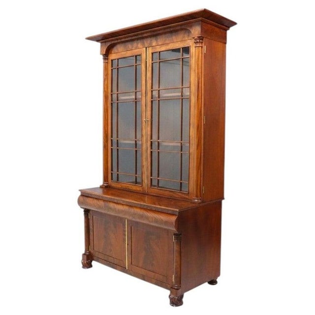 An impressive antique American Empire step back cupboard, crafted from rich mahogany around 1840, features a distinctive...