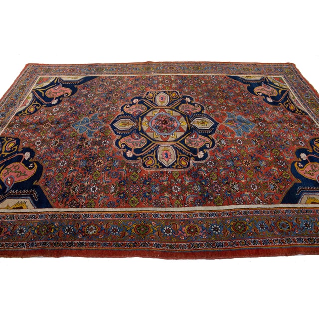 Beautiful antique Bidjar hand-knotted wool rug with a red color field. This Persian rug has a blue frame with multicolor...