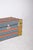 Wooden trunk in shades of green, blue, and orange. with a sturdy structure and decorated with vibrant graphic patterns,...