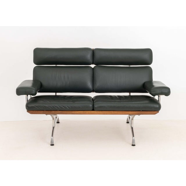 Charles and Ray Eames for Herman Miller Two-Seat Sofa, with green leather upholstery on walnut frame above aluminum eight...