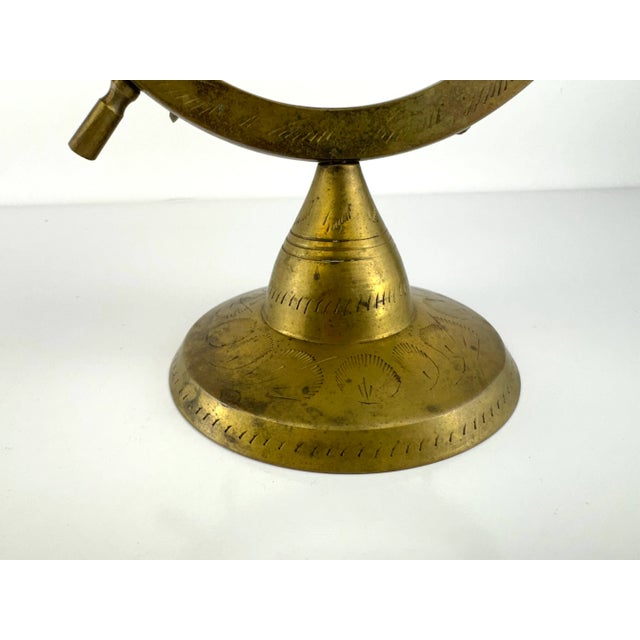 A striking vintage brass ship wheel display stand, artfully crafted and richly patinated, bringing an element of nautical...