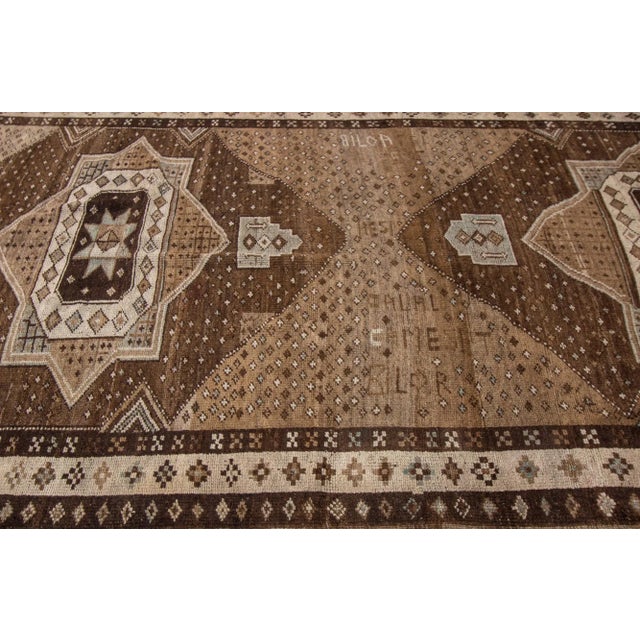 Beautiful vintage Anatolian hand-knotted wool rug with a brown color field. This piece has a beige accent in a gorgeous...