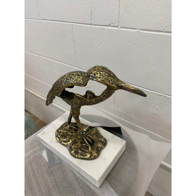 The ultimate beachcomber, this sanderling in antique brass standing on white marble is poised for the catch.