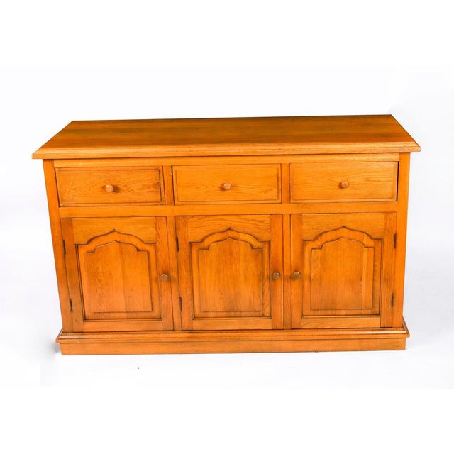 An exquisite English solid oak sideboard, made by Brights of Nettlebed and dating from the late 20th Century. This...