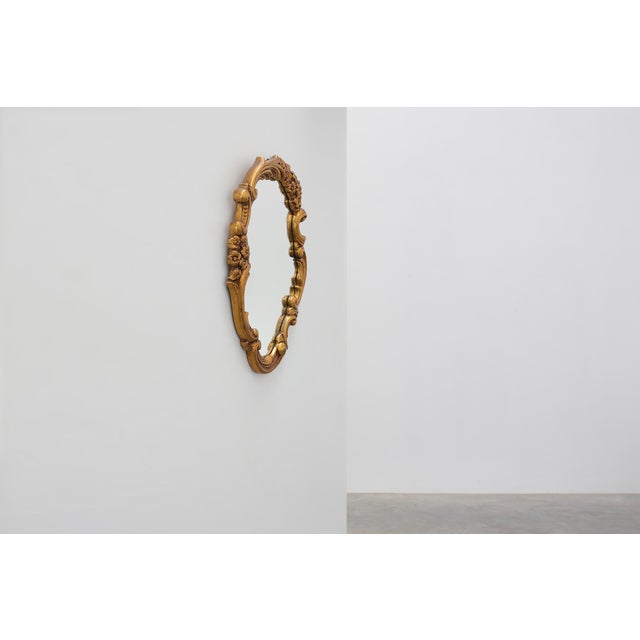 This elegant Italian mirror is designed in the Rococo manner, featuring an asymmetrical cartouche-shaped frame enriched...