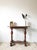 This console table, crafted around 1880 in the Historicist style, is likely made of walnut or chestnut wood and features...