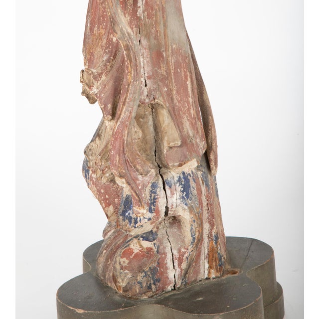 Beautiful carving of Guanyin, shown standing on a rocky outcrop, mounted on a lobed wooden base. It was once used as a...