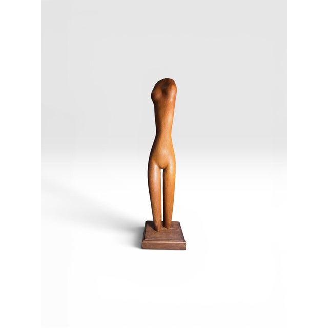 A striking vintage hand-carved wood sculpture depicting a stylized female nude figure. Beautifully executed in a warm...