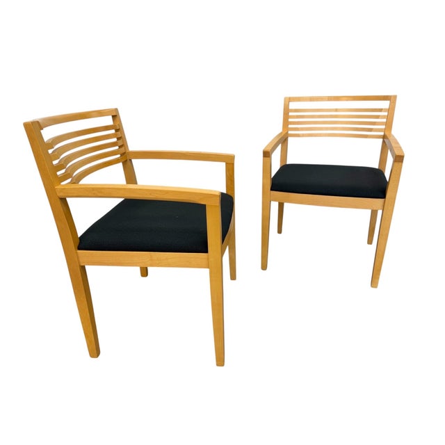 A stylish pair of vintage Knoll solid wood arm chairs dating to the 1990s. These beautifully constructed chairs feature...
