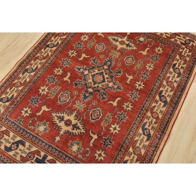 A tribal Caucasian Kazak rug hand-knotted with fine wool on a cotton foundation. This rug features a central medallion...