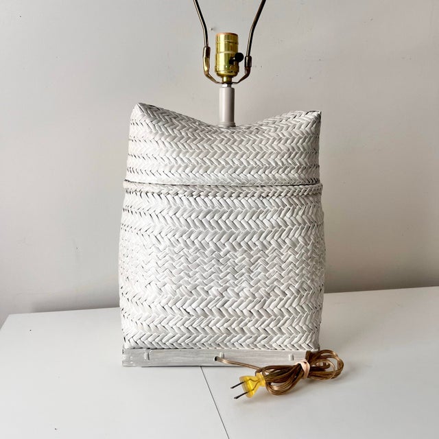 Beautiful vintage contemporary style coastal light wicker basket table lamp with woven details. The piece has a sack like...