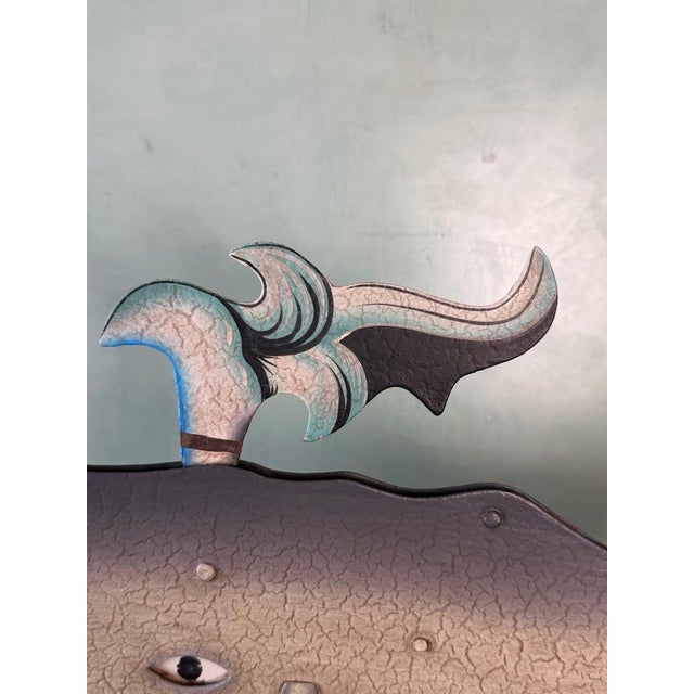 A whimsical vintage folk art kinetic sculpture depicting a stylized whale rising above curling ocean waves. The piece...