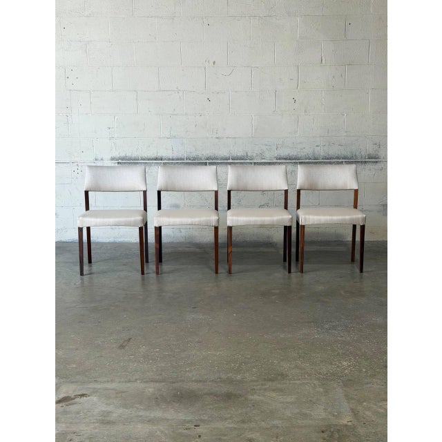 This set of four dining chairs features a minimalist silhouette with an open back design. Clean lines create a highly...