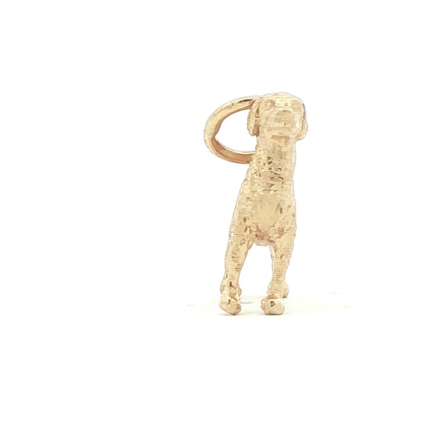 A vintage 14k yellow golden retriever dog charm. Detailed craftsmanship with a textured finish. Features a loop for...