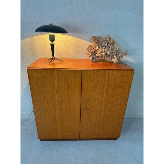 Vinatge cabinet in teak veneer. Handleless and sleek. Including 2 shelves and original key. Cabinet is generally in good...