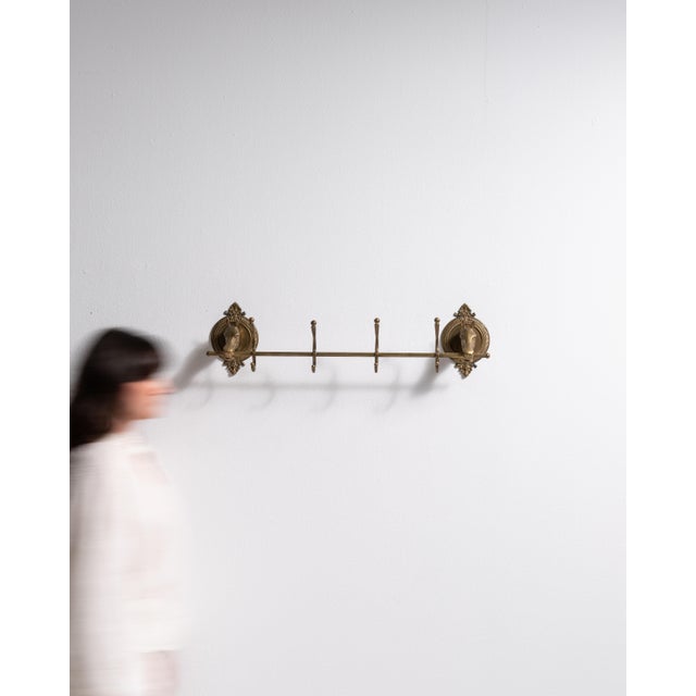 This mid 20th century coat rack from France is finished in brass. It is distinguished by its horse head hooks, a detail...