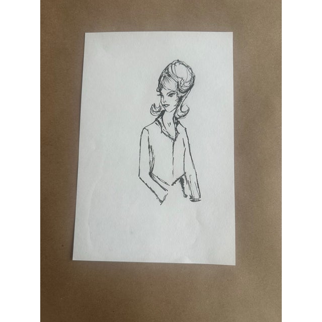 A delicate ink sketch of a mid-century inspired female figure, capturing elegance through minimal linework. The expressive...