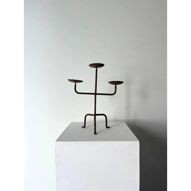 A charming iron candle holder with three stems and tripod legs. This french vintage candelabra displays a simple minimal...