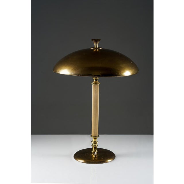 Elegant swedish grace table lamp executed in brass and bakelite, produced by nordiska kompaniet in the 1930s. The design...