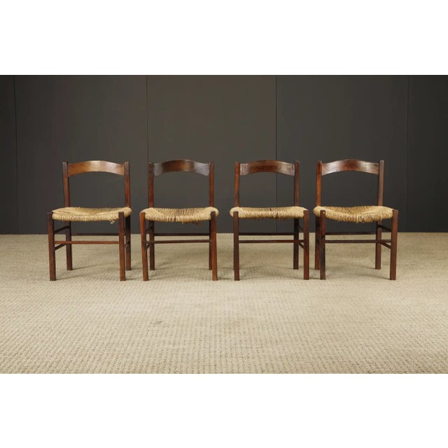 A beautifully worn set of four handcrafted dining chairs, likely of French origin, dating to the mid-20th century. These...