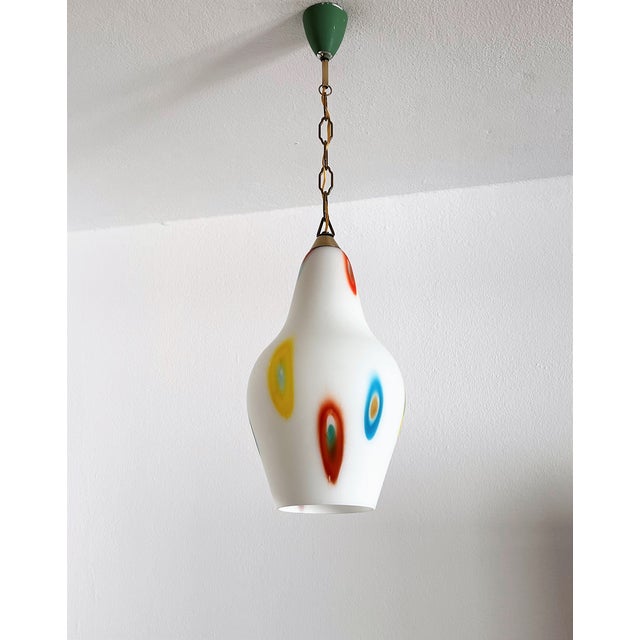 Beautiful set of two glass pendant lamps made in Italy, in the 1970s. The colorful funny pendants are made of white Murano...