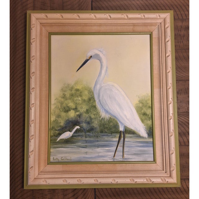 A beautiful, authentic 1976 oil painting depicting a white egret in a marshy landscape. Signed by the artist 'Betty...