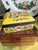 A striking chinoiserie porcelain lidded box finished in a richly saturated imperial yellow ground, adorned with finely...