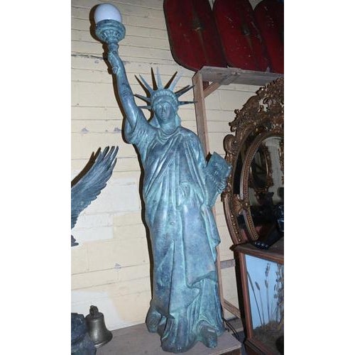 A striking large sculpture of the statue of liberty, cast in metal with a verdigris patinated finish, capturing the iconic...