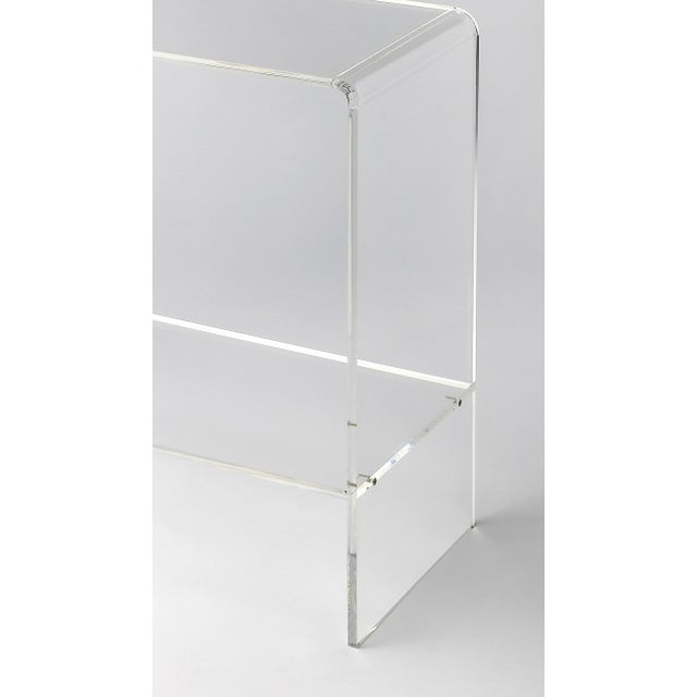 Crafted from clear acrylic and featuring a minimalist modern design, this console table's understated look lets your...