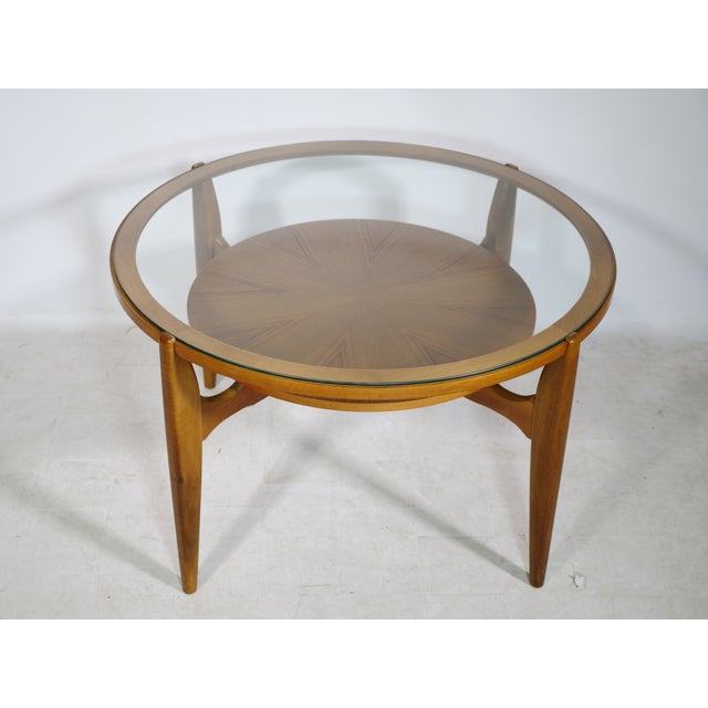 Vintage design coffee table by Wilhelm Renz from the 1960s. A round glass top is set in a walnut frame, beneath which is a...