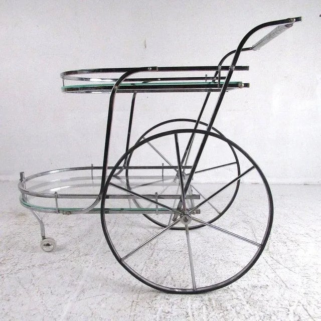 Stylish chrome two-tier serving or bar cart ideal for home or office use. Dimensions: H 33 in. x W 38 in. x D 22 in...