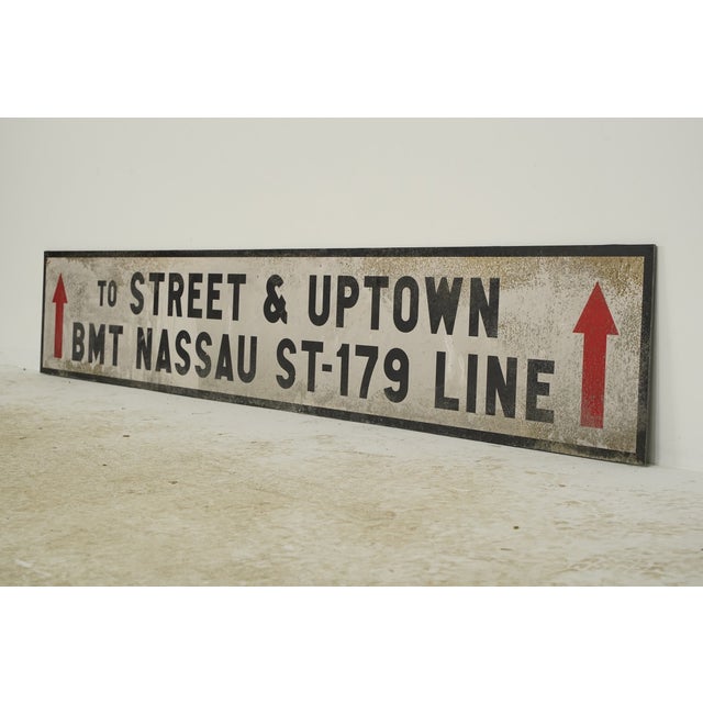 Reclaimed movie set street sign made of plastic foam board in white and black colors with red arrows. The sign reads "To...