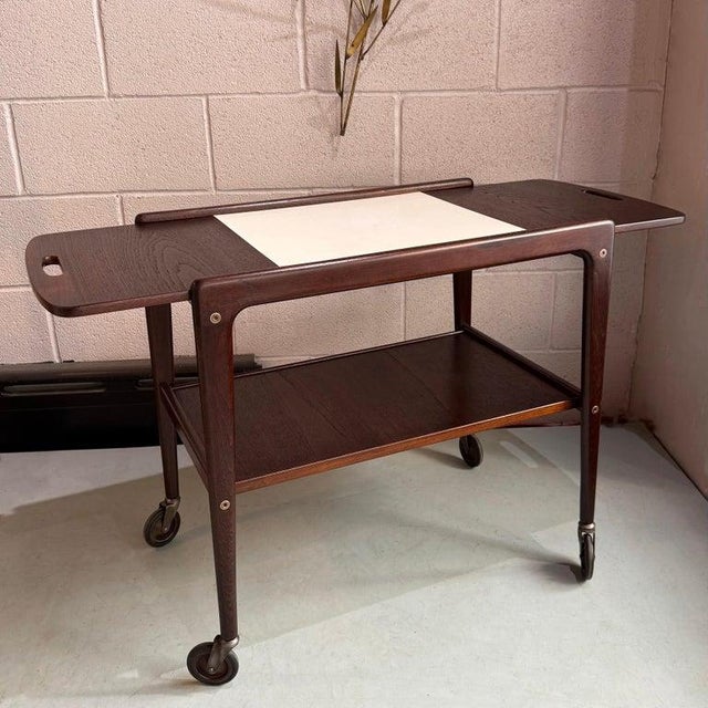 This Scandinavian Modern, rosewood, extendable drop leaf bar cart or serving trolley was created by the Swedish architect...