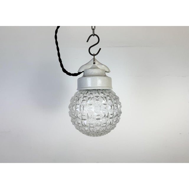 Vintage industrial light made in former Czechoslovakia during the 1970s. It features a white porcelain top and a glass...