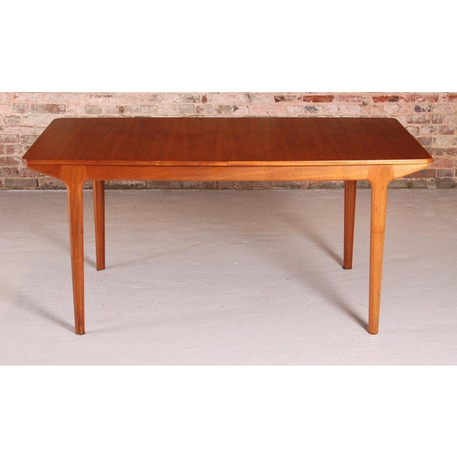 A mid century extending dining table designed by mcintosh and produced in the 1960s. Constructed in teak with a softly...