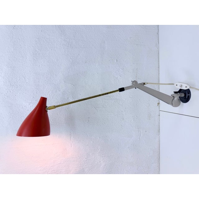 One adjustable wall lamp from the 1950s, single-bulb, E27 socket. Brass, metal, painted red, gray, and black. Good used...