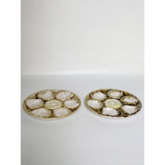 Pair of ceramic oyster plates, France, 1970s. Charming pair of glazed ceramic oyster plates, designed with six individual...