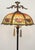 Art Nouveau style floor lamp with an ornate brass frame and a reversed painting textured glass shade. This requires two...