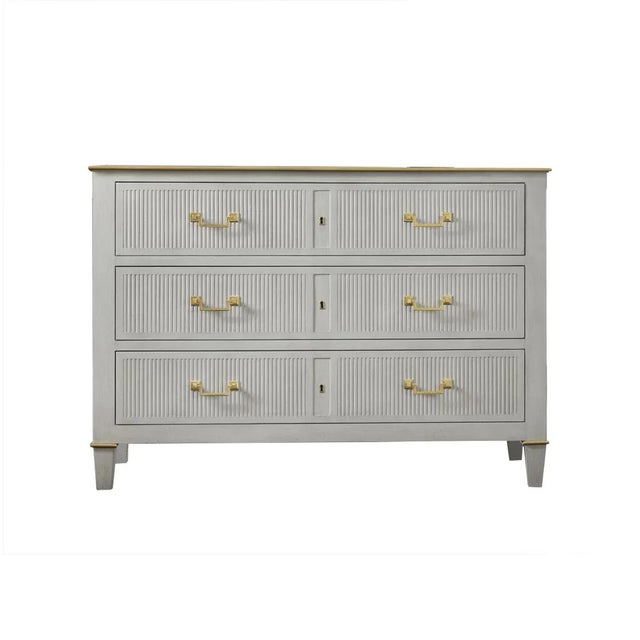 The Dutch Painted Commode is fitted with three long drawers and has an antiqued painted finish. With brass molded trim,...
