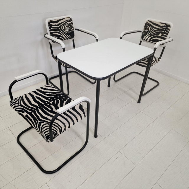 Elegant Bauhaus-style dining set comprising a rectangular table and three cantilever chairs (two armchairs and one lower...