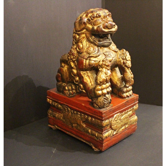 Early-mid 20th century carved, red lacquer and gilt female foo lion, Chinese. Attached to conforming hollow stand base...