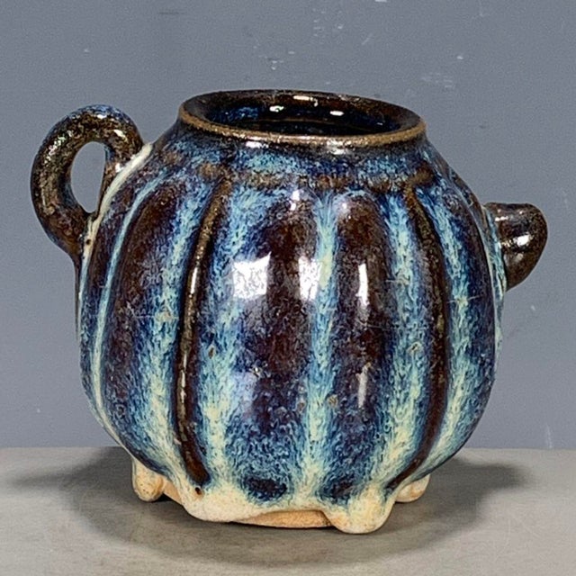 A striking small Chinese ceramic jug or pitcher. The vessel features a ribbed, melon-like body with a small pouring spout...