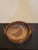 A vintage handmade pottery dish, its warm brown glaze lending a rustic charm. This versatile piece is perfect for serving...