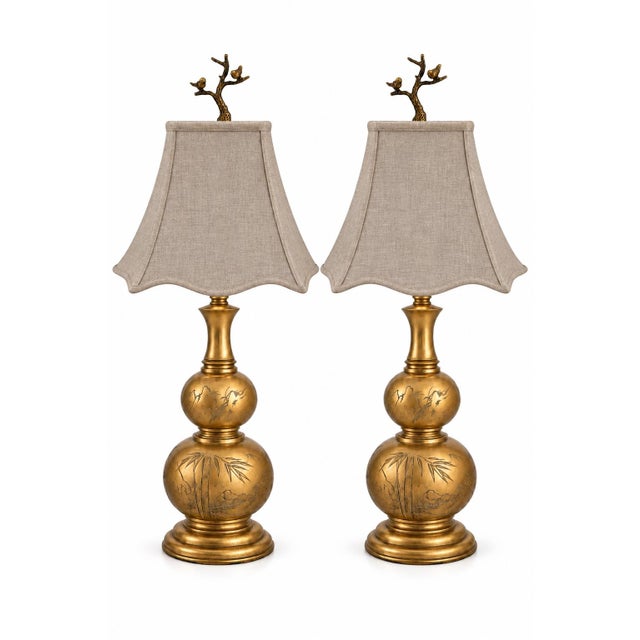 An extraordinary matched pair of substantial antique brass table lamps, distinguished by their sculptural double-gourd...