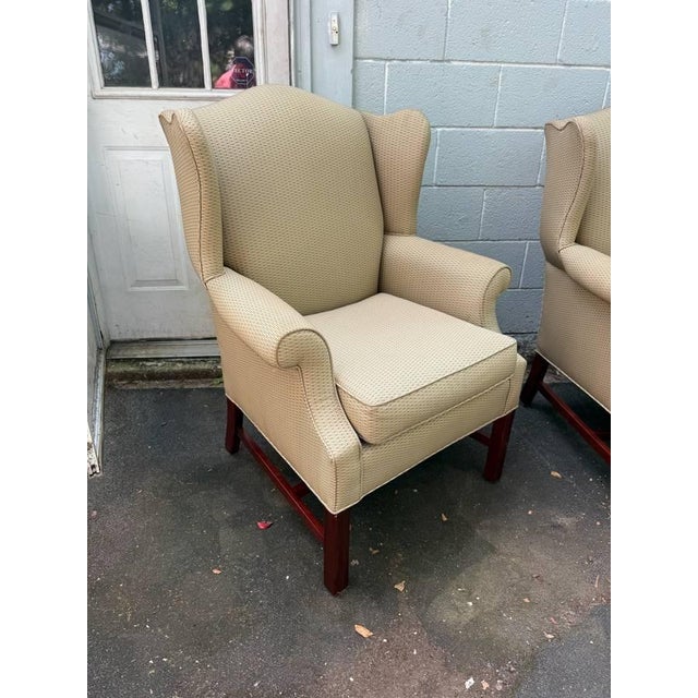 Pair of wingback chairs by St. Timothy Chair Company American made, high quality. It features curved upholstered back...