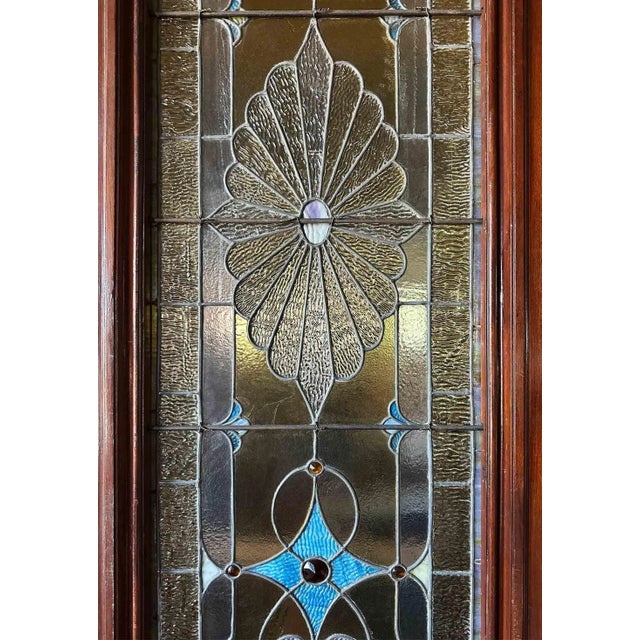 Large pair of antique late 19th century mahogany Victorian stained glass sliding pocket doors featuring intricate stained...