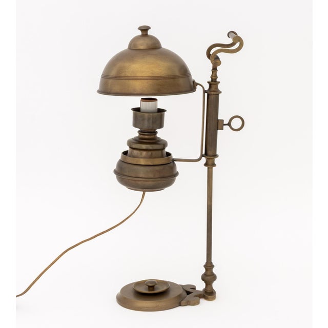 Vintage Brass Adjustable Electrified Oil Lamp, with hand and circular base. 19.25" H x 10.5" W x 6.75" D. Provenance: From...